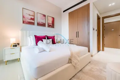 a bedroom with a large white bed with red pillows at City Views 1BR Close to Golf Course & Attractions, Binghatti Venus, Jumeirah Village Circle by Deluxe Holiday Homes in Dubai