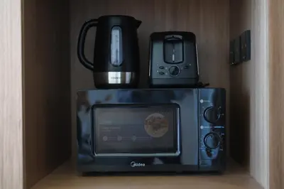 a microwave with a coffee pot on top of it at Cosy Studio in Binghatti House in Dubai