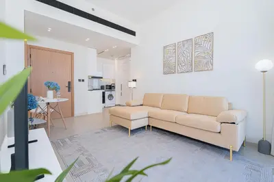 a living room with a couch and a kitchen at Escape24 Modern 1BR Balcony with City View in Dubai