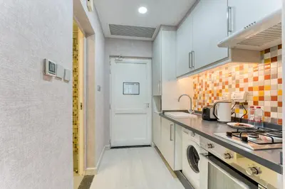 a kitchen with a sink and a white door at Octopus - Iconic Palm Studio With Views in Dubai