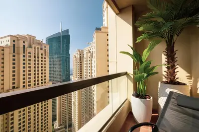 a balcony with two potted plants and a view of a city at Daniels 1BR at Sadaf JBR in Dubai