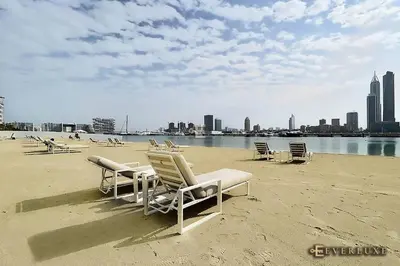 a group of lounge chairs sitting on a beach at Chill 1br W Beach Views & Private Beach Access in Dubai