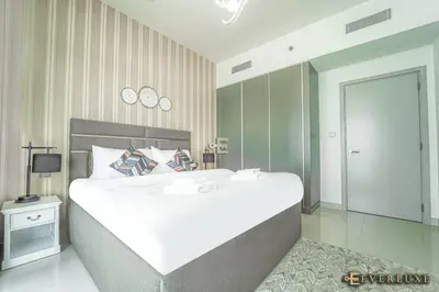 a large white bed in a bedroom with a mirror at Chill 1br W Beach Views & Private Beach Access in Dubai