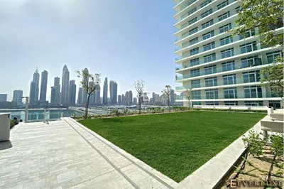 a park in front of a tall building at Chill 1br W Beach Views & Private Beach Access in Dubai