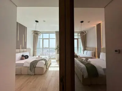 a bedroom with two beds and a large window at Luxueux Ammenities Tower, Sea View, Near to Beach in Dubai