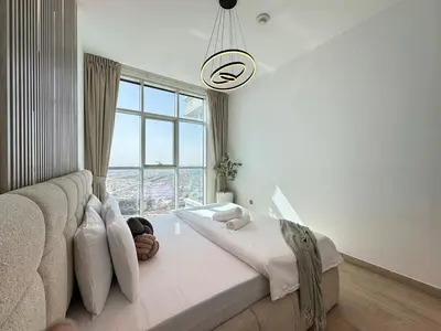 a bedroom with a couch and a large window at Luxueux Ammenities Tower, Sea View, Near to Beach in Dubai