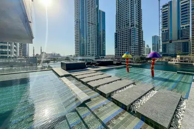 a swimming pool with umbrellas on top of a building at High End 1 Bedroom with Exquisite Layout in JLT in Dubai