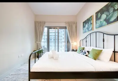 a bedroom with a bed with a large window at 012 - Dubai South in Dubai