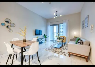 a living room with a table and a couch at 012 - Dubai South in Dubai