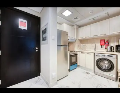 a kitchen with a refrigerator and a black door at 012 - Dubai South in Dubai