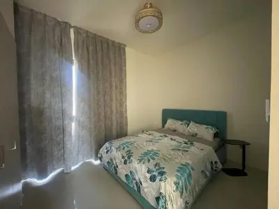 a bedroom with a bed and a window with curtains at 014 - Damac Hills in Dubai