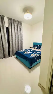 a bedroom with a bed with a blue comforter at 014 - Damac Hills in Dubai