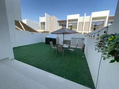 a patio with a table and chairs and an umbrella at 014 - Damac Hills in Dubai
