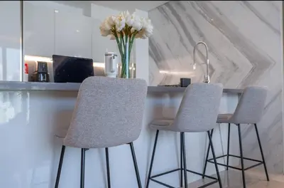 a kitchen with two chairs and a counter with a vase of flowers at Luxury Apt with Full Burj Khalifa Skyline Views in Dubai