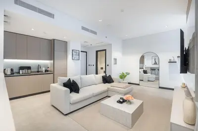 a living room with a white couch and a table at Water Front Apartment, Burj Khalifa Views in Dubai