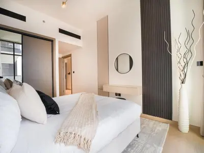 a bedroom with a white bed and a mirror at EasyGo- Stylish 1BDR with view and astonishing Facilities JVC in Dubai