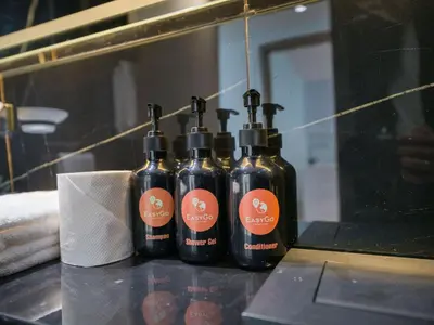 three bottles of alcohol sitting on a counter in front of a mirror at EasyGo- Stylish 1BDR with view and astonishing Facilities JVC in Dubai
