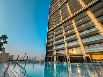 a large building with a swimming pool in front of it at EasyGo- Stylish 1BDR with view and astonishing Facilities JVC in Dubai
