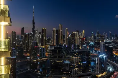 a view of a city at night at SIMPLY COMFORT Apartments at Nobles Tower Luxury Burj View in Dubai