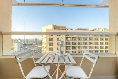 a table and two chairs on a balcony with a view at Luxury 1BR with Lake View Near Downtown Balcony and Pool Access in Dubai