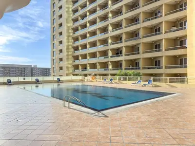 a swimming pool in front of a large building at Luxury 1BR with Lake View Near Downtown Balcony and Pool Access in Dubai