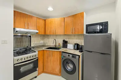 a kitchen with a refrigerator and a washer and dryer at Luxury 1BR with Lake View Near Downtown Balcony and Pool Access in Dubai