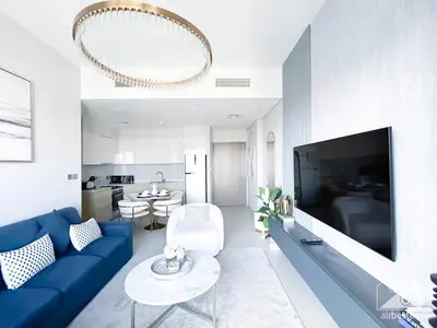 a living room with a blue couch and a tv at Luxurious Burj Royale 1B Apt With Balcony & City Views in Dubai
