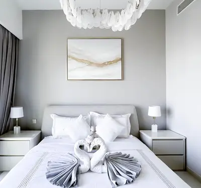 two towel swans are sitting on a bed at Luxurious Burj Royale 1B Apt With Balcony & City Views in Dubai