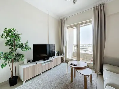 a living room with a tv and a large window at Marina 1 Bedroom Gem in Dubai
