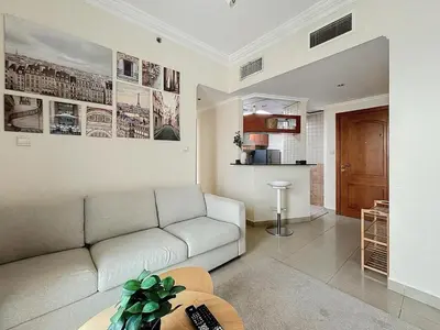 a living room with a couch and a table at Marina 1 Bedroom Gem in Dubai