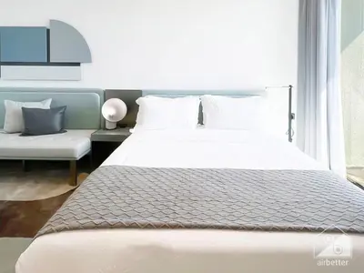 a bedroom with a large white bed and a couch at Tranquil Studio Getaway in Dubai's MAG 920 in Dubai