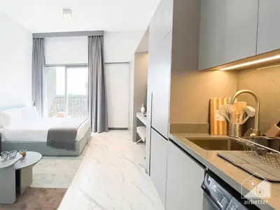a hotel room with a bed and a kitchen at Stylish Studio Getaway in Dubai's MAG 920 in Dubai