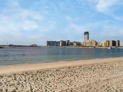 a beach with a city in the background at Homes & Beyond I Pristine 2BR with Waterfront view in Dubai