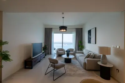 a living room with a couch and a tv at Homes & Beyond I Pristine 2BR with Waterfront view in Dubai