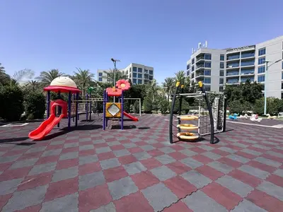 a playground in a parking lot with slides and swings at Family friendly 2-bedroom in Dubai