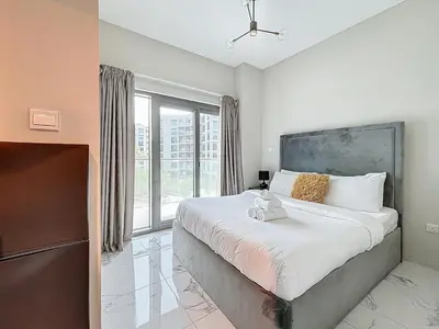 a bedroom with a large bed and a large window at Family friendly 2-bedroom in Dubai