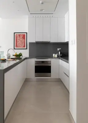 a kitchen with white cabinets and a black oven at Luxury Jumeirah canal front designer stay sleeps4 in Dubai