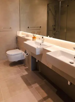 a bathroom with two sinks and a toilet and a mirror at Luxury Jumeirah canal front designer stay sleeps4 in Dubai