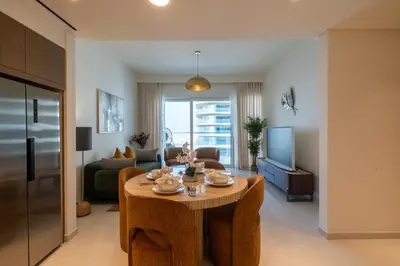 a living room with a table and a couch at Homes Beyond I Modern 2BR Getaway with Beach Access in Dubai