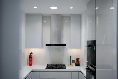 a kitchen with white cabinets and a stove top oven at Souk Al Bahar Dubai Fountain and Burj Khalifa view from the Balcony, 2 mins walk to Dubai Mall by Norbu Holiday Homes in Dubai