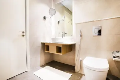 a bathroom with a toilet and a sink and a shower at 5 Star Stay, Infinity Pool with Burj Khalifa Views in Dubai