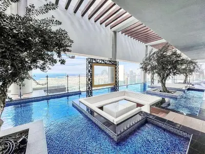 a large swimming pool with a white couch in a building at 5 Star Stay, Infinity Pool with Burj Khalifa Views in Dubai