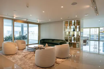 a living room with a couch and a table and chairs at Homes Beyond l Relaxing 1BR Oasis with Beach Access in Dubai
