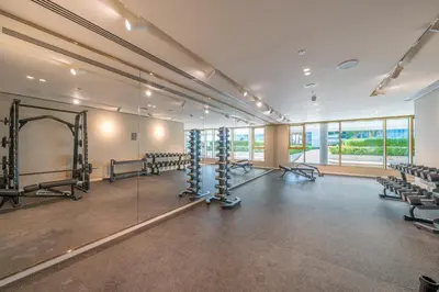 a large room with rows of chairs and a gym at Homes Beyond I 1BR Coastal Haven Walk to the Beach in Dubai
