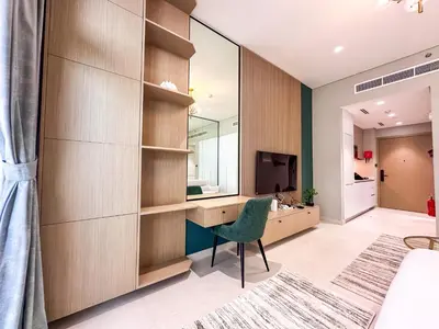 a bedroom with a desk and a room with a television at Stylish Studio in the Heart of Al Furjan 20AB4 in Dubai