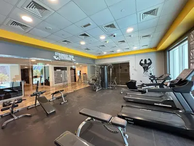 a gym with treadmills and cardio machines in it at Premium Large Studio in Hamilton residency business bay Marasi Drive Dubai in Dubai