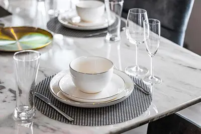 a table with plates and wine glasses on it at Daniels 3BR at Princess Tower With Full Palm Jumeirah View in Dubai