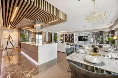 a kitchen and living room with a table and a dining room at Daniels 3BR at Princess Tower With Full Palm Jumeirah View in Dubai