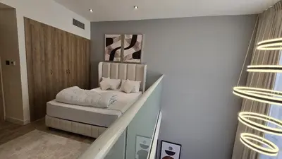 a bedroom with a bed and a stair case at 1 bed townhouse in Dubai