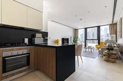 a kitchen with a counter and a living room at Modern 1Br in the Heart of Dubai by SIMPLY COMFORT in Dubai